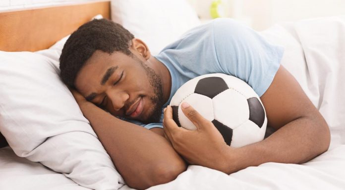 om cu minge de fotbal in pat